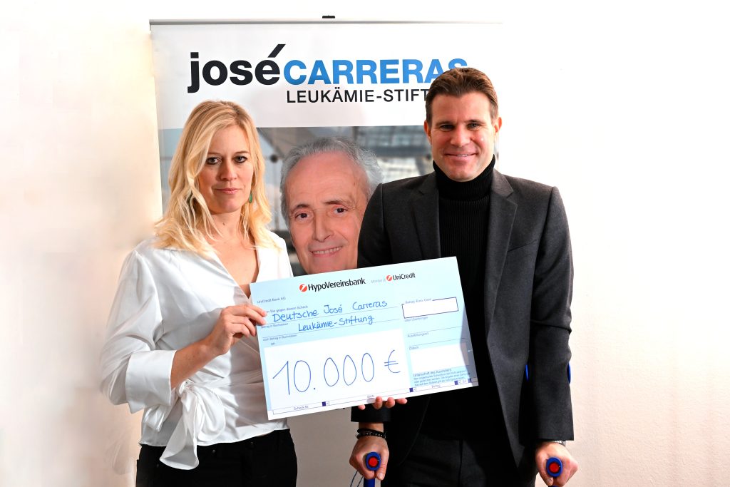 Weltschiedsrichter und Münchens Host-City-Botschafter Dr. Felix Brych übergibt einen Spendenscheck in Höhe von 10.000 Euro an Dr. Ulrike Serini, Geschäftsführerin der José Carreras Leukämie-Stiftung